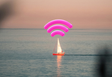 A sailboat floats on calm water at sunset. Large pink wifi signal graphics show above the boat, appearing as if the boat is broadcasting a wireless signal. The sky is a soft pink and orange colour,blending into the blue of the ocean.